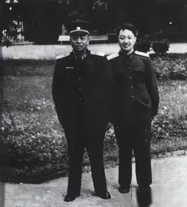这张珍贵的老照片拍摄于1954年。画面之中，彭德怀元帅与警卫员景希珍并肩而立，二