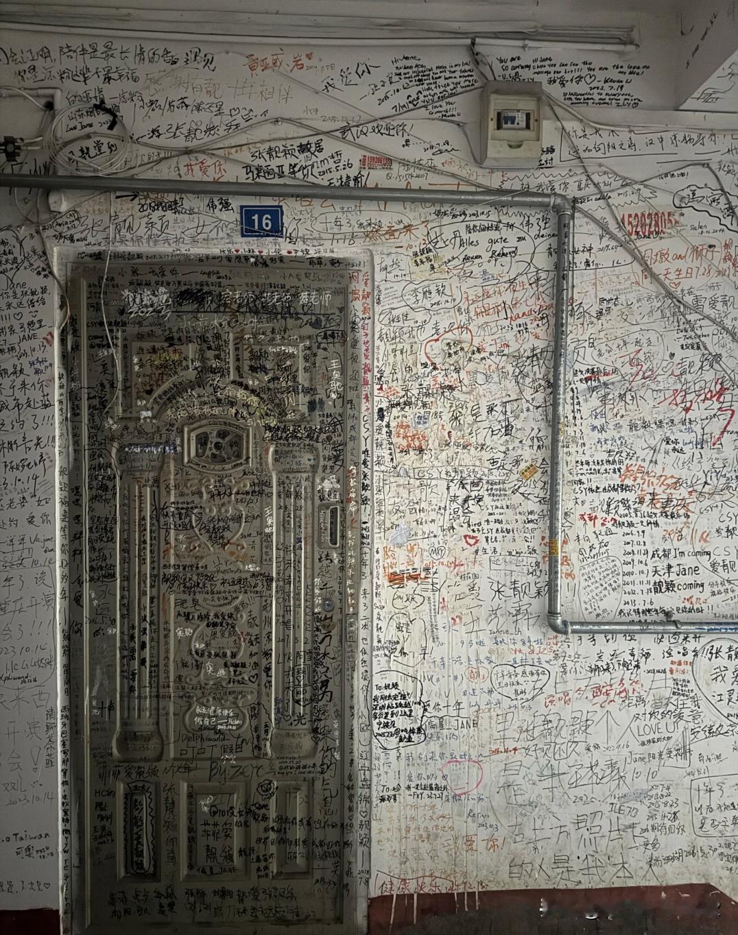 张靓颖旧居（成都）。在外墙上全部都留下了打卡的痕迹，好像小广告一样，细则