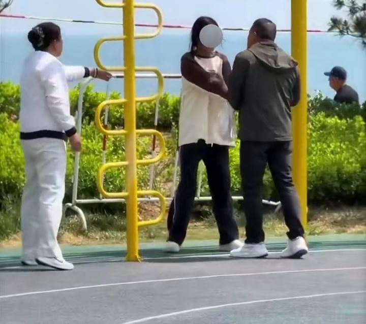 山东烟台一公园内，一小学生模样的女孩正在玩秋千。此时领着小孩的俩位老人直奔女孩的