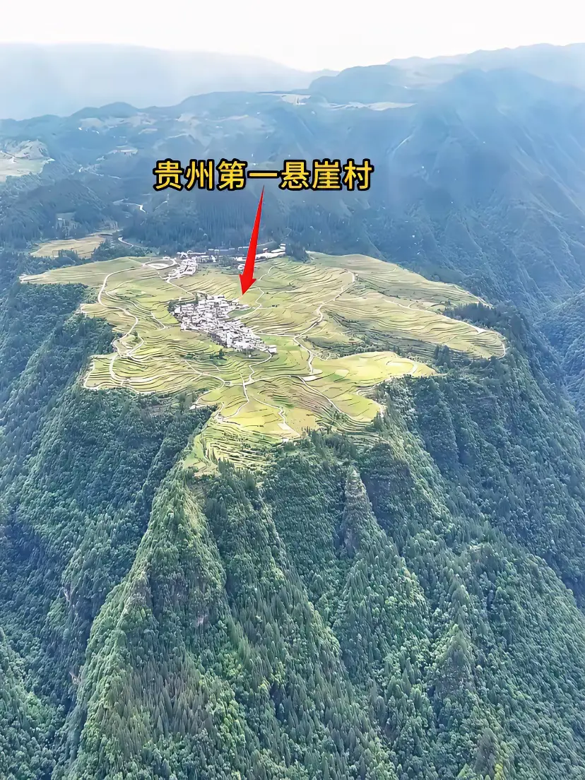贵州悬崖顶上的村庄，三面断崖，房屋四周都是水田