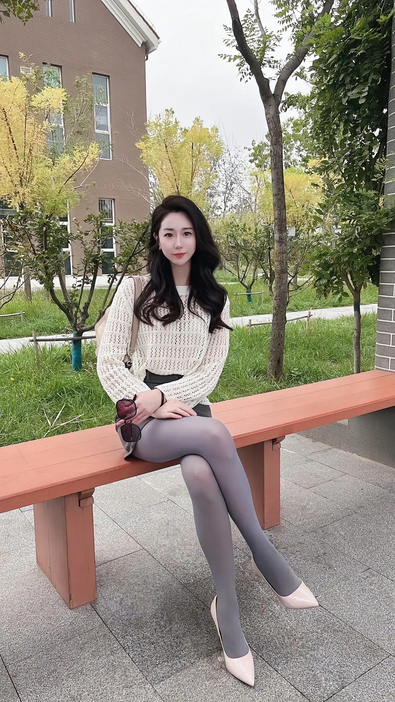 优雅坐于长椅，秋日暖阳洒落，时尚穿搭显气质。