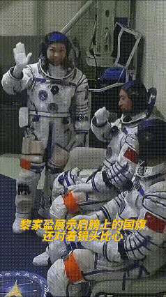 黎家盈在摄影机拍到自己的那一刻，用手指了指衣服上的国旗，还比了个心。什么意思
