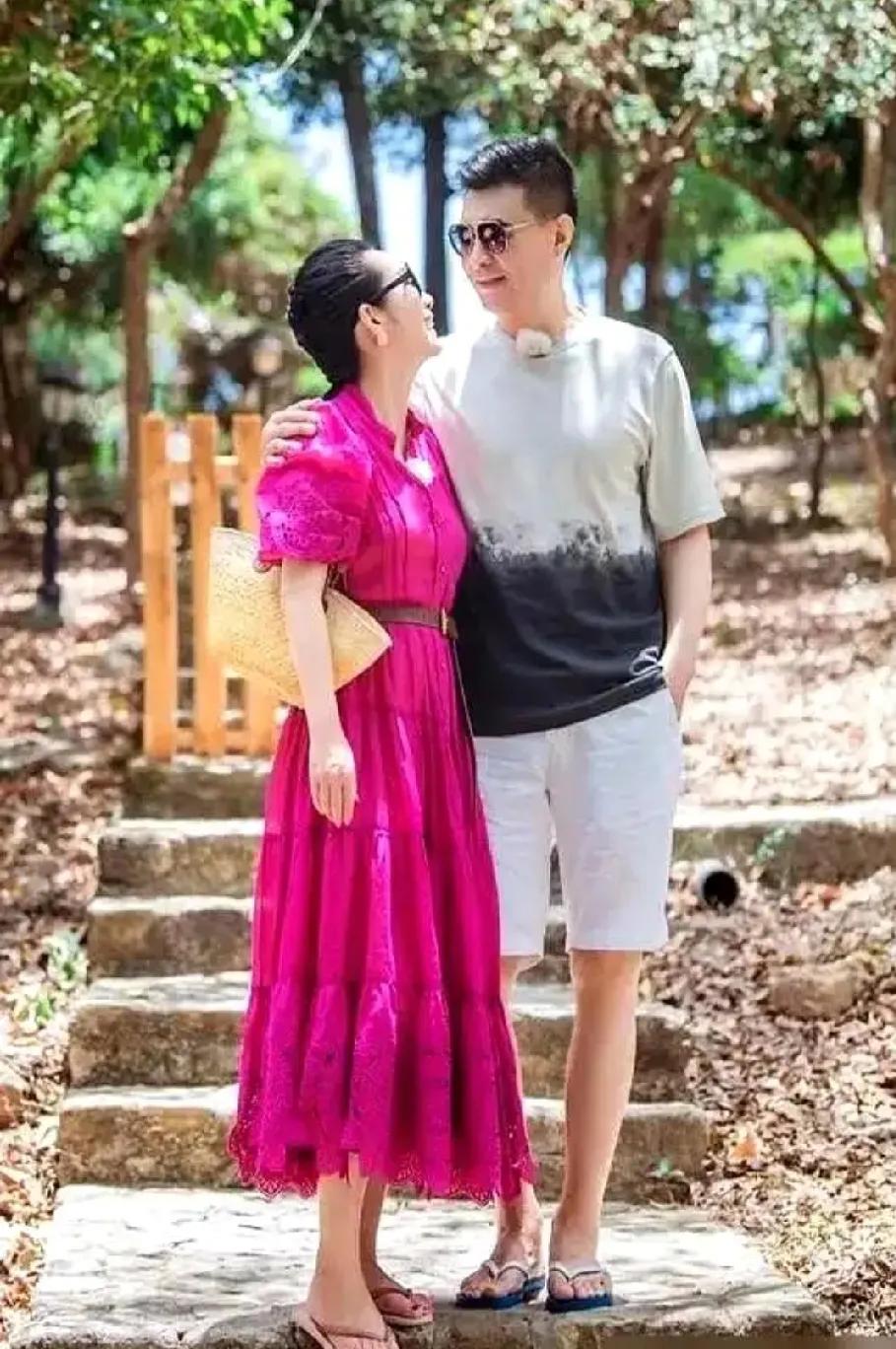 被秦海璐夫妇的甜蜜旅行照甜到啦💕海边露台，她一袭玫红长裙明艳动人，与丈夫依偎