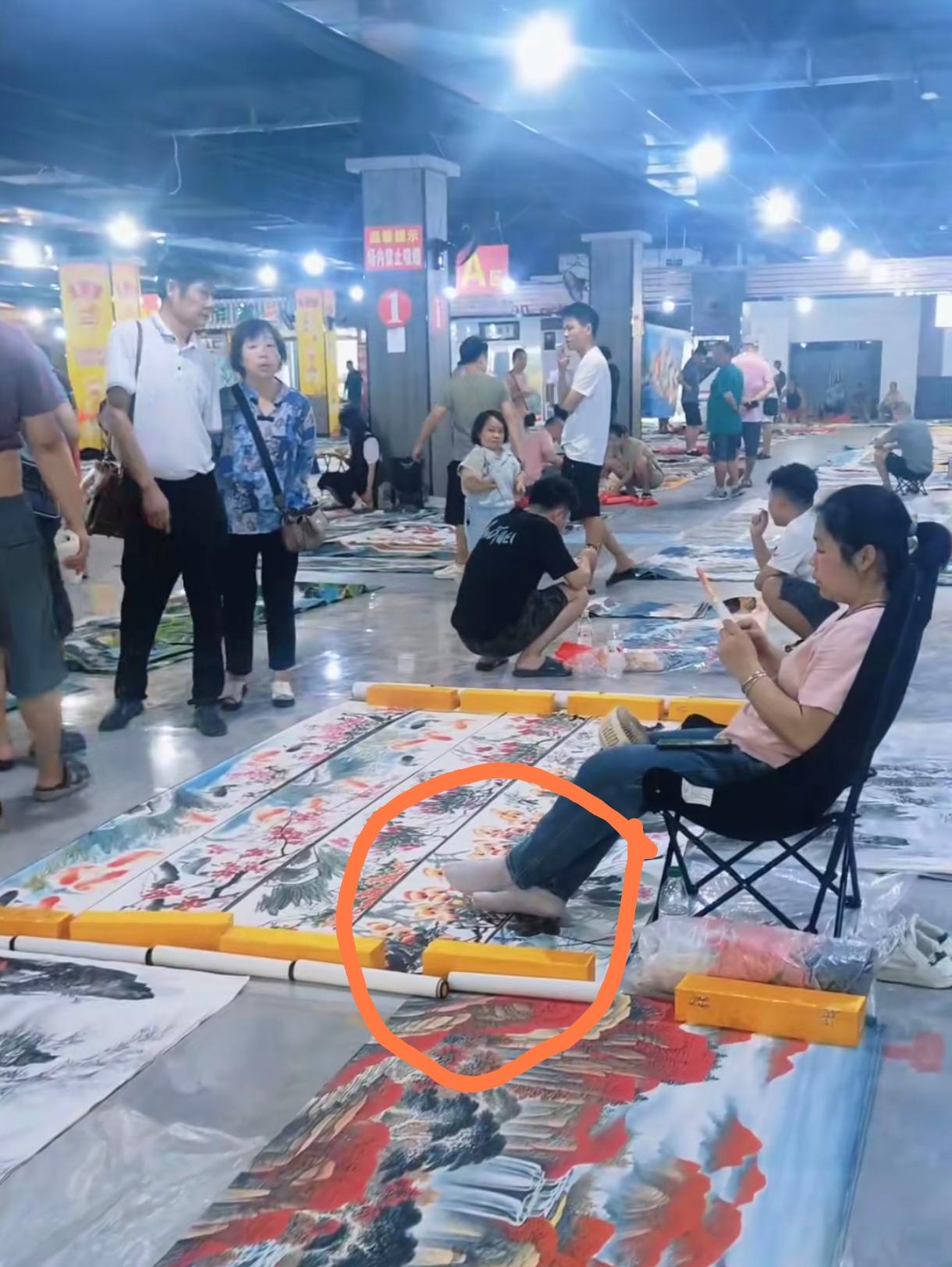 为何现在的字画市场每况愈下？看看这位卖画的大姐，脱了鞋直接把脚放在要卖的画上面，