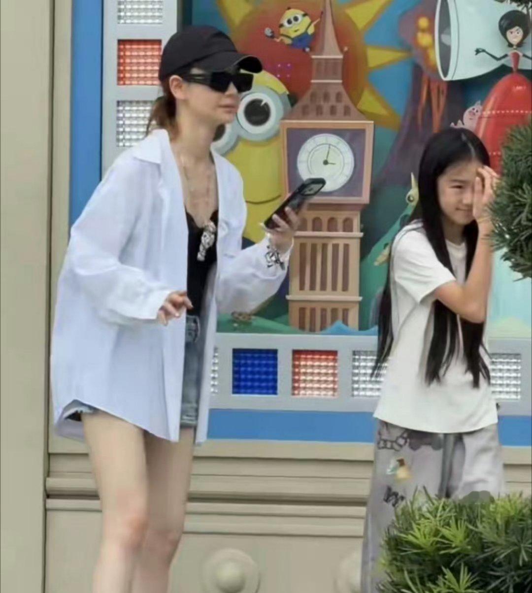 戚薇带着女儿度假，当天戚薇身穿吊带宽松衬衣和短裤，整个人白的发光，但瘦得前胸贴后