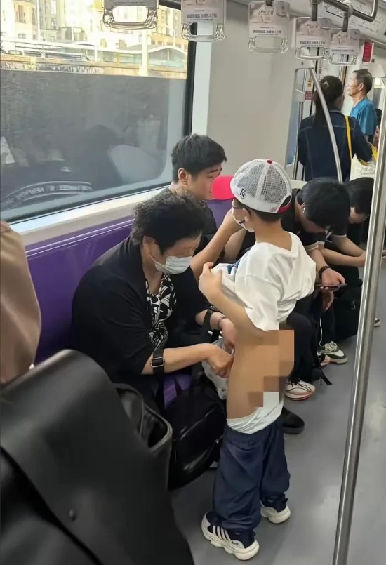 上海地铁内，因为孙子尿急，奶奶用塑料袋为孙子接尿的一幕被网友拍照发到网络上，并配