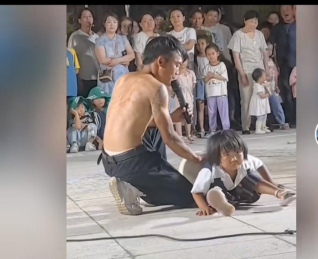 三岁女童街头卖艺，看哭读者和现场围观者。只见一个30多岁的男人，拿了一个直径几