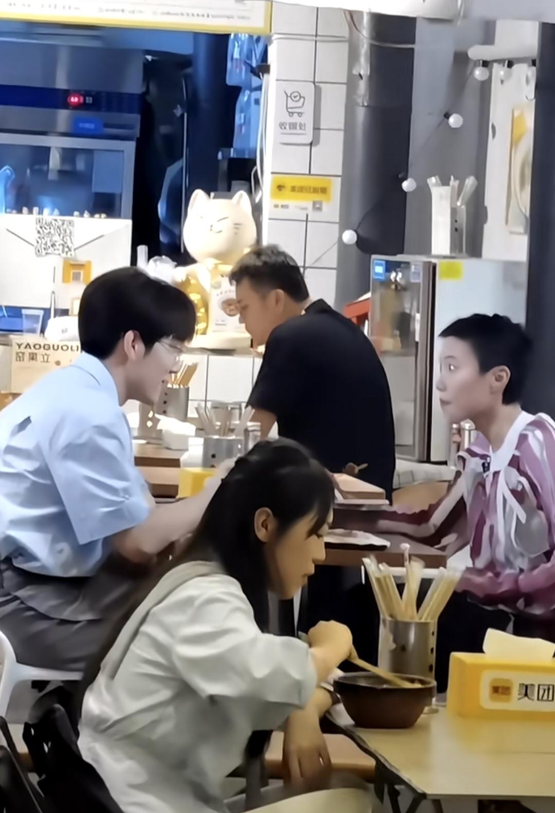 窦靖童穿条纹衬衫，对面坐着戴眼镜，西装革履，文质彬彬的郑方一，两人在一家小餐