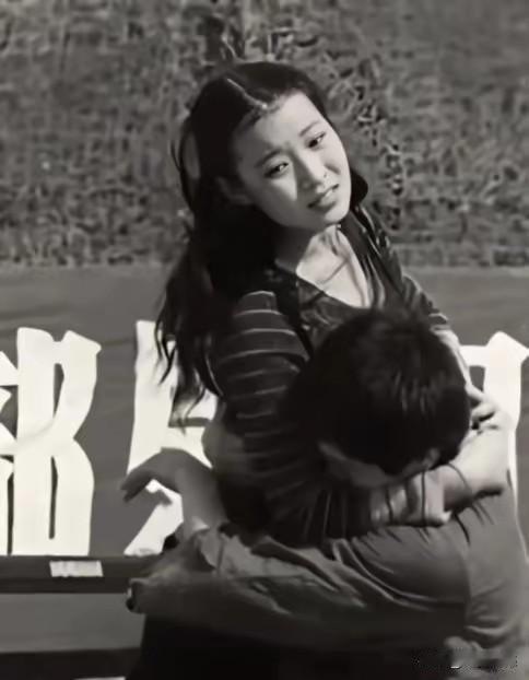 这张照片拍摄于40年前，照片中的女子是一个到老山前线慰问的文艺工作者，被她抱在怀
