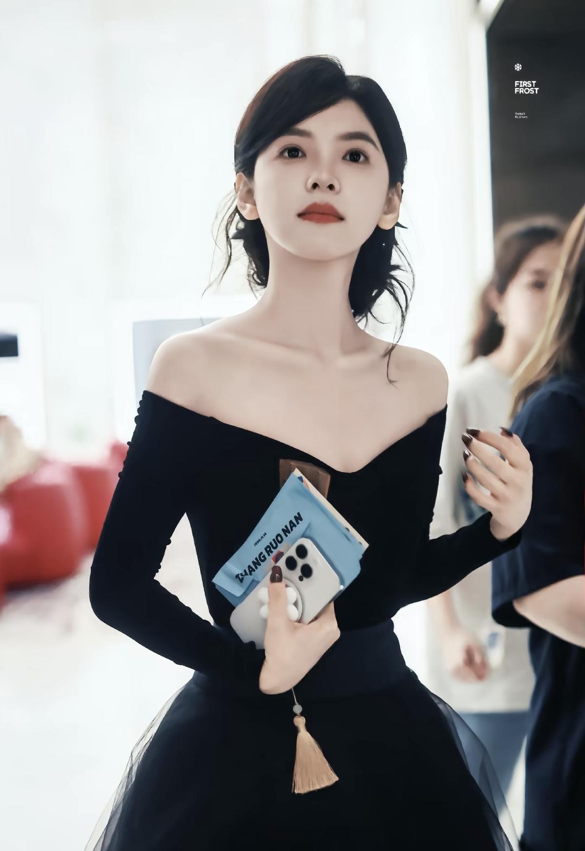 黑色一字肩精准勾勒迷人锁骨，薄纱裙摆缀着细碎光泽，行走间似暗夜流转的星光