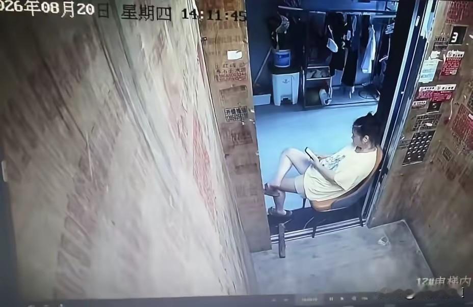 独霸电梯蹭空调！监控视频里，一名白衣女子搬来一把小椅子，四只椅脚跨在电梯门槛内