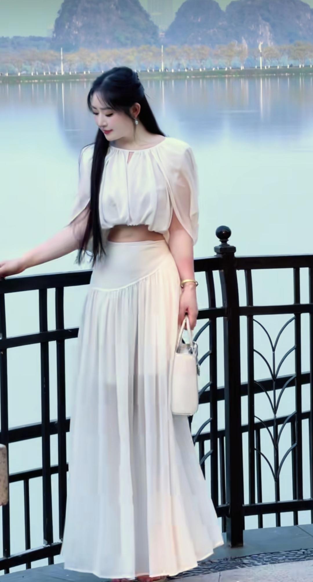 湖边倚栏眺望，婀娜多姿，宛如仙气飘飘的白衣女神。湖边美女照美少女与美景分享