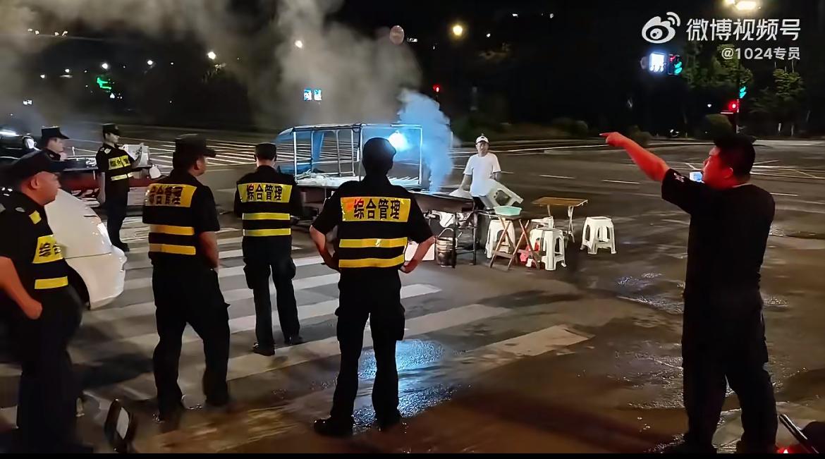 把烧烤摊摆在大马路中央，也太任性了吧？一大波城管来处理。这一次赞他们。旁边拍照的