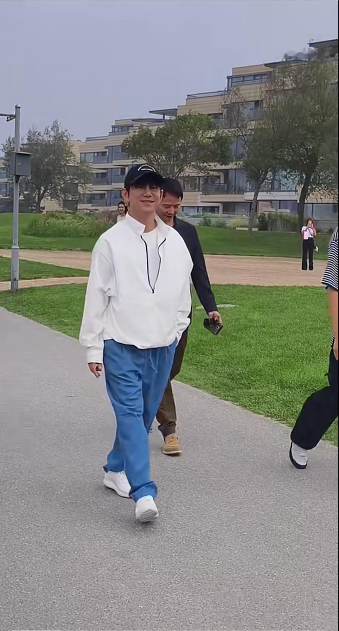 何炅老师，白上衣配蓝裤子，棒球帽一戴，整个人清爽干净。特别有精神。一路面带笑容