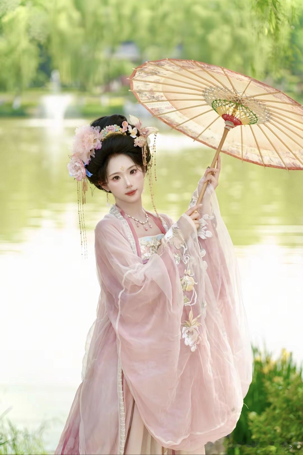 粉衣佳人撑油纸伞，花间漫步如入画。这身装扮也太仙了。江南烟雨美人