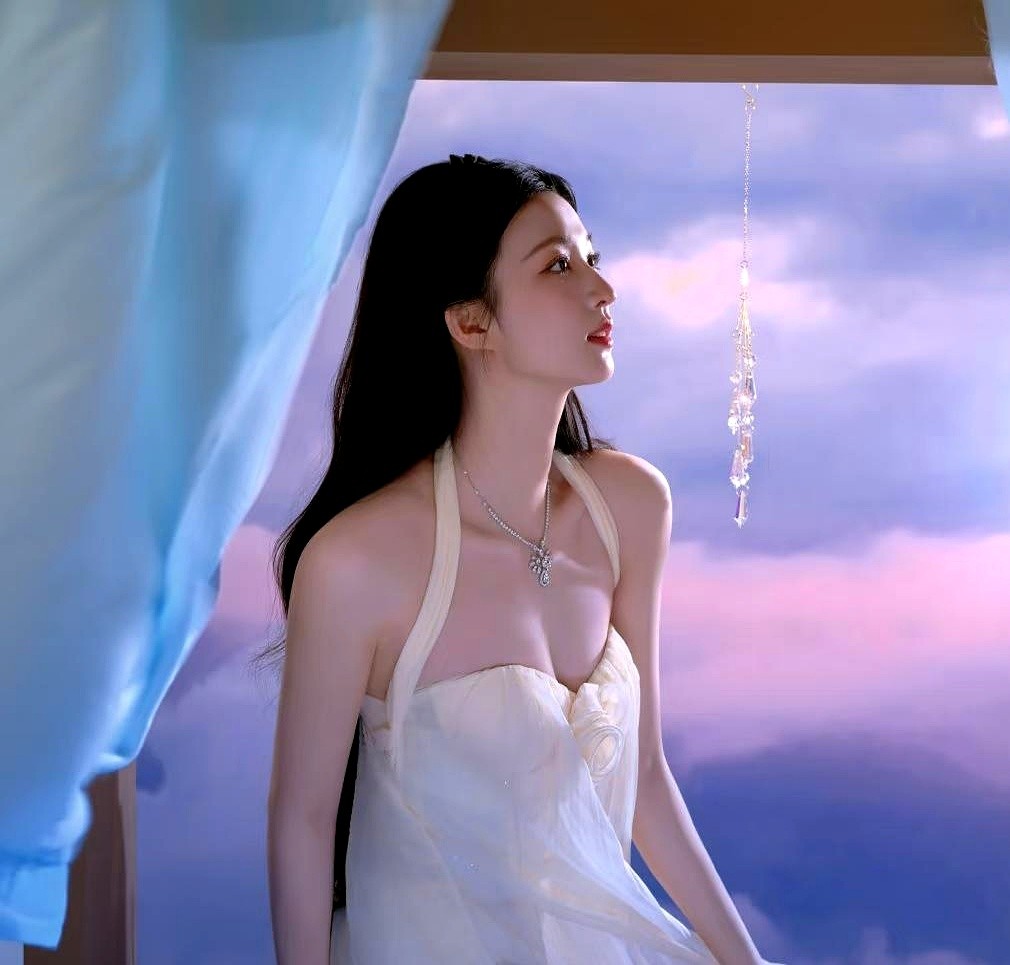 镜头前，一件浅杏色的挂脖薄纱裙，没加多余的点缀。99年出生的王楚然站在那，透视薄纱贴着肩颈线条。她没