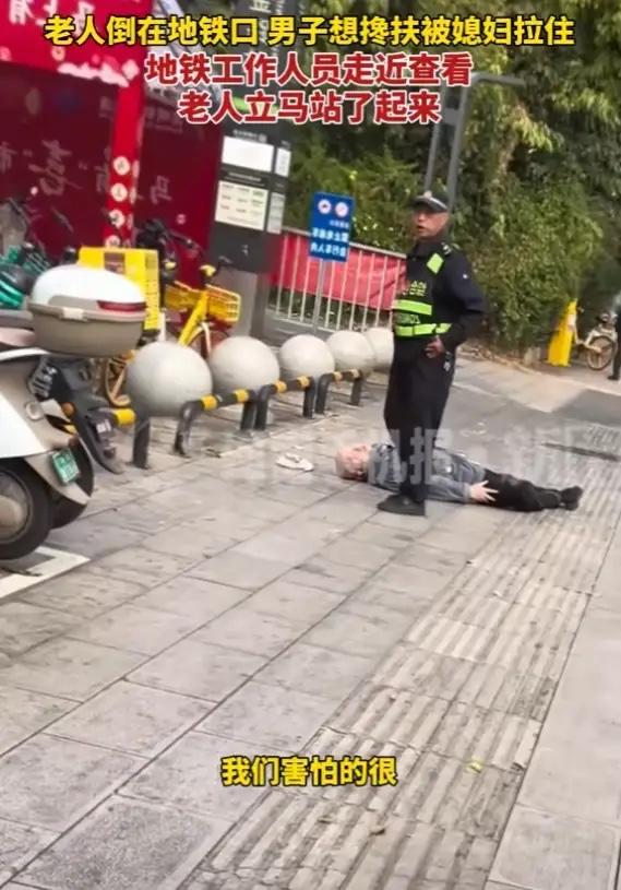 云南，男子见一老人一动不动躺在地铁口的地上，他想上前扶起老人，却被媳妇一把拉住，