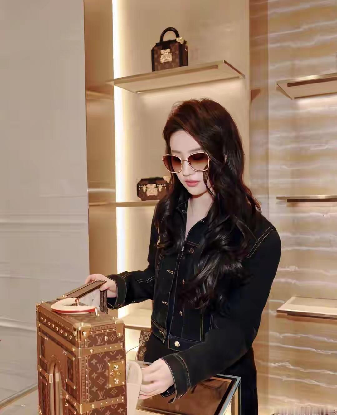 刘亦菲黑色牛仔套装，白色锁边添了一抹俏皮，搭配红色帽子更显灵动。