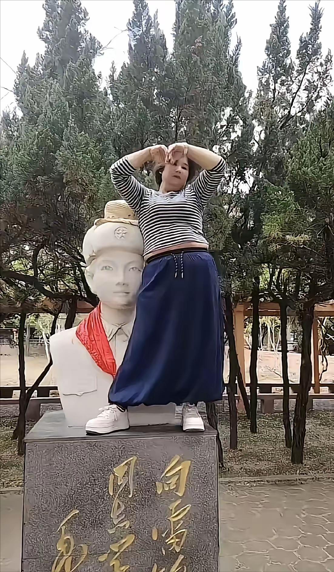 这大妈没轻没重，跑到雷锋雕像上站着拍照。雷锋在很多人心里是有分量的，你拍照就拍照