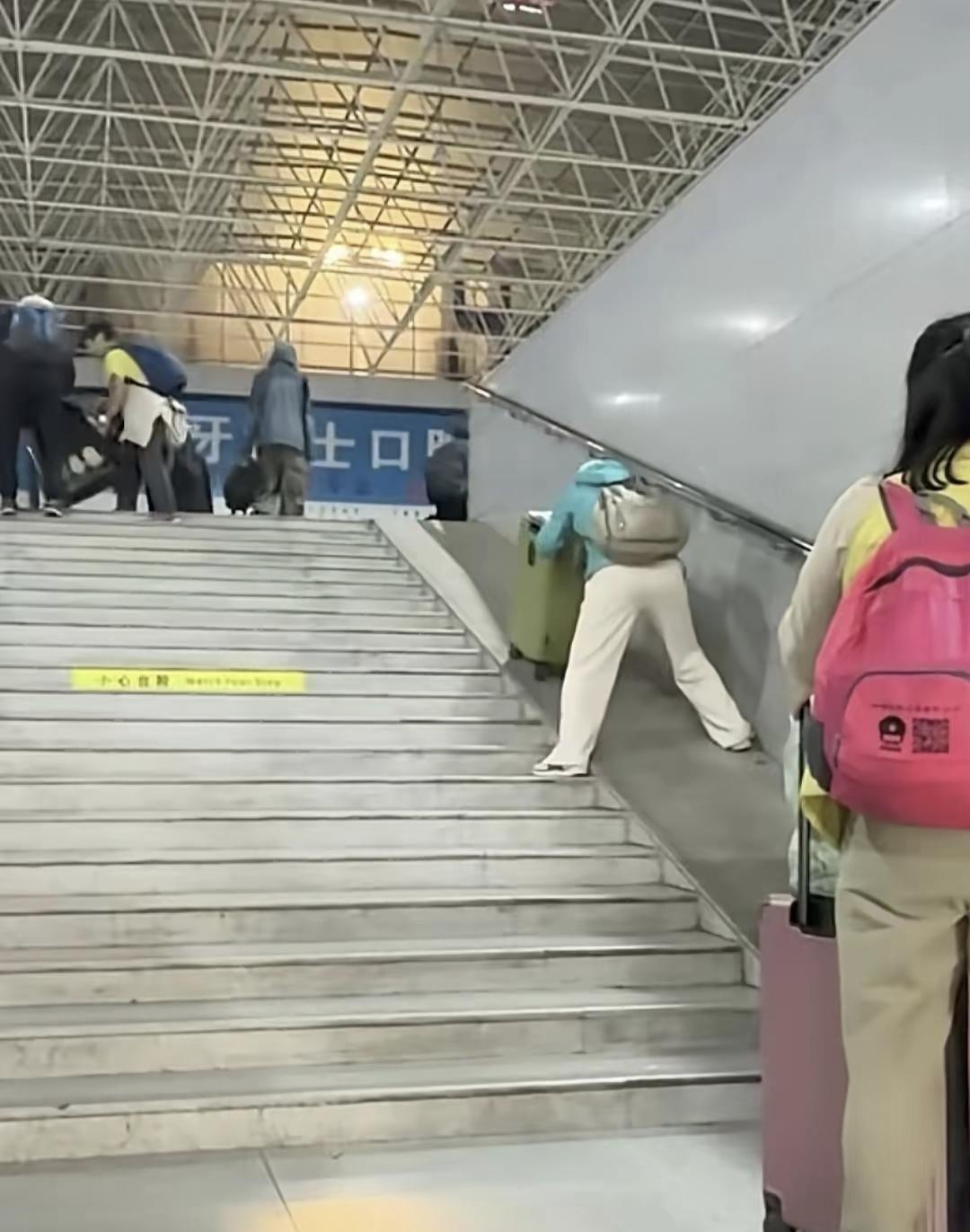 “这口碑无敌了！”女子奋力推行李箱出站，途中差点被重力压倒，周边却无一人上前帮忙