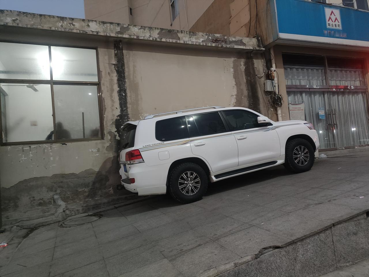 这是个高手早晨送孩子上学，发现小区门口一辆车就这么直接停在路边这有一个斜坡，