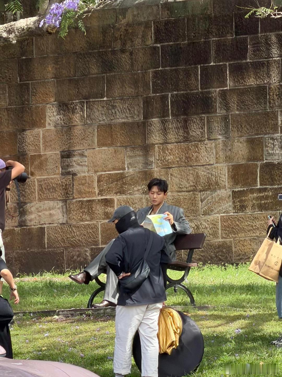 悉尼街头偶遇张晚意，坐长椅看地图，老砖和紫花当背景，他那身衣服哪怕皱了点都不影响
