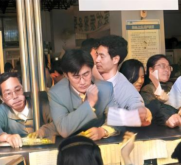 这是1994年12月9日，上海邮电大厅里挤满了人。有的人被挤得站不稳脚。他们急切