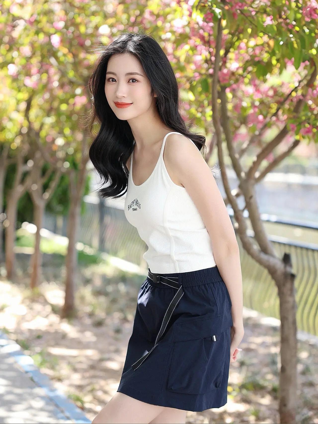 ☀️春日林荫道，阳光穿过花枝落在肩头，白背心搭藏青短裙，松弛感拉满的一天。