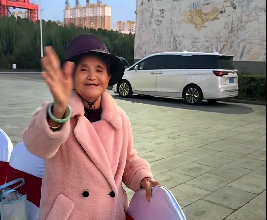 那件粉色工装，九年前她穿去录节目，九年后婆婆穿上身，孙子在地里掰玉米，她站在旁边