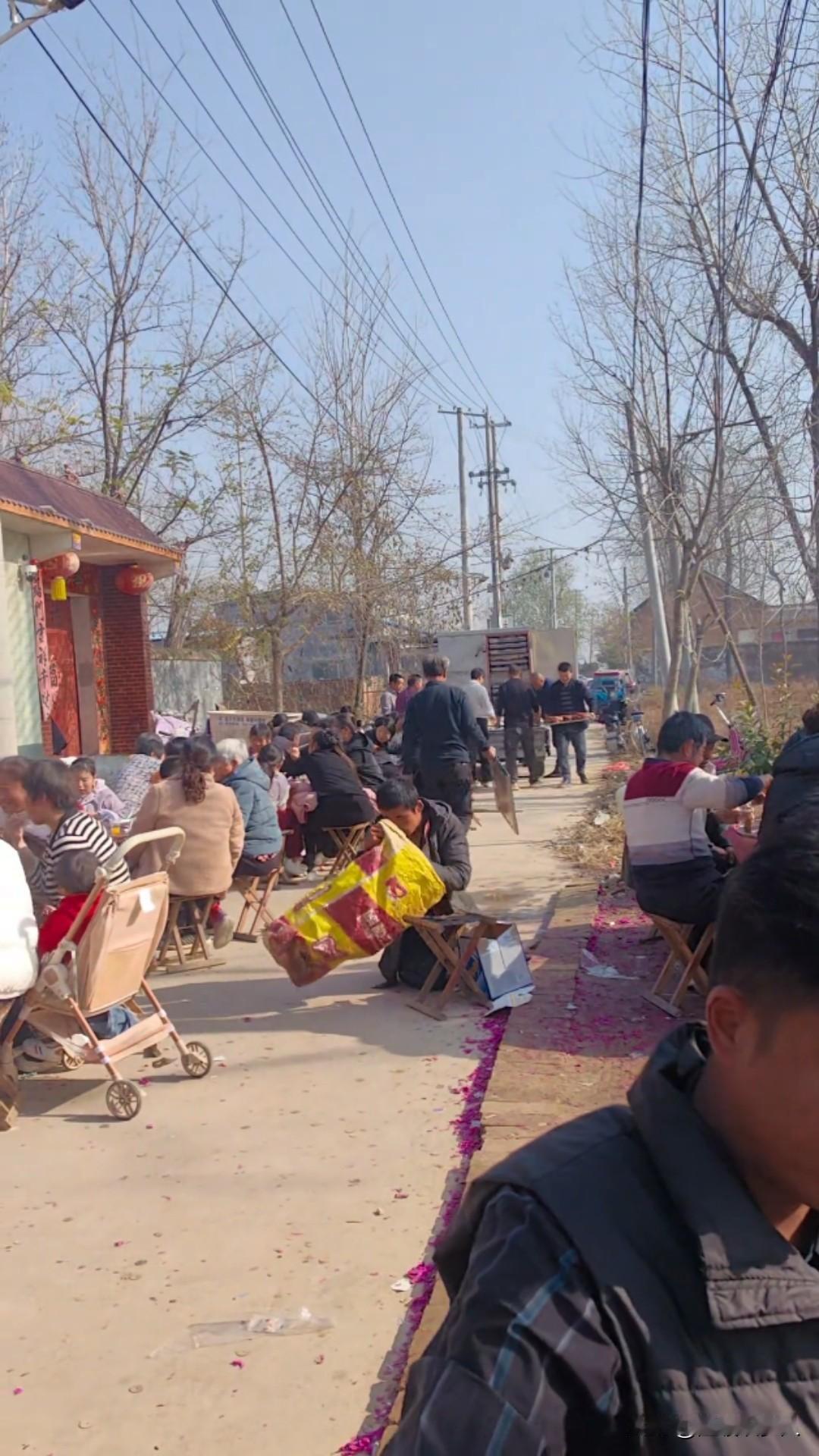 近日，山东菏泽，一场寻常的乡村露天宴席上，一位靠板凳艰难挪动身体的残疾青年，在众