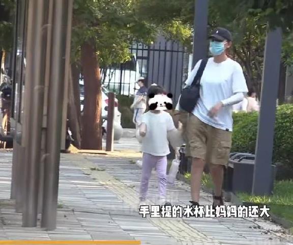 热依扎带女儿散步好有爱！小家伙自己拎着大水壶，跟在妈妈身后慢慢悠悠地走，每一步都