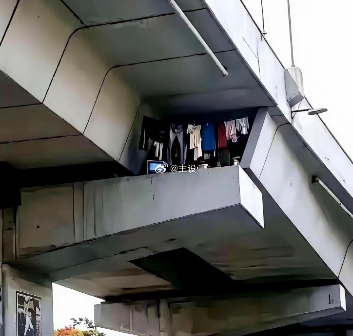 重庆寸滩大桥下，桥墩夹缝里，有人搭了个家。衣服叠得整齐，碗筷洗净码放，甚至还有台