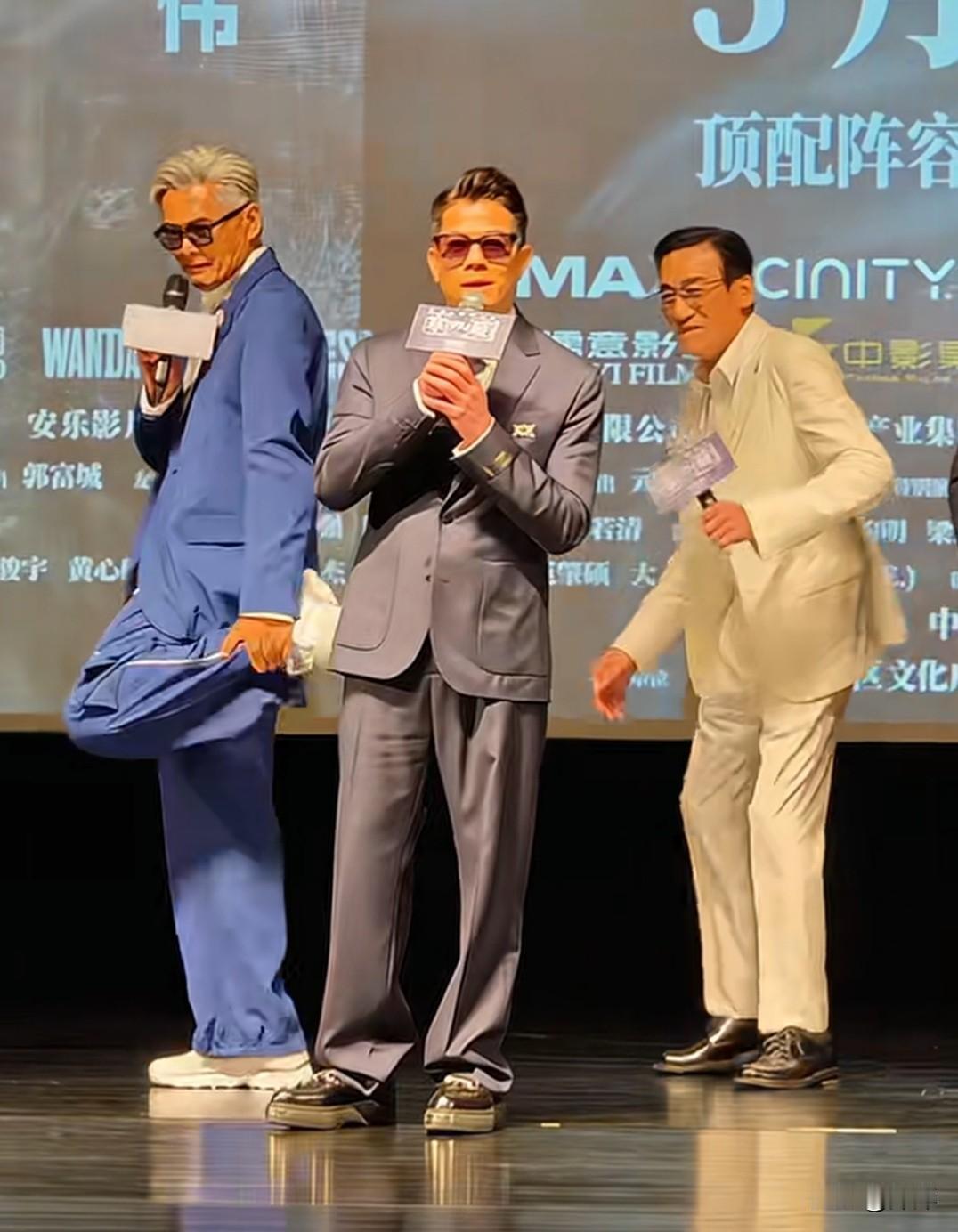 周润发.梁家辉.郭富城在活动上，郭富城在前边讲话而周润发和梁家辉在后面模仿起了郭