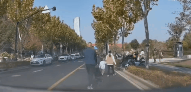 11月23日，一上海网友曝光行车记录仪：自己开车在马路上正常行走，突然遇到一家三
