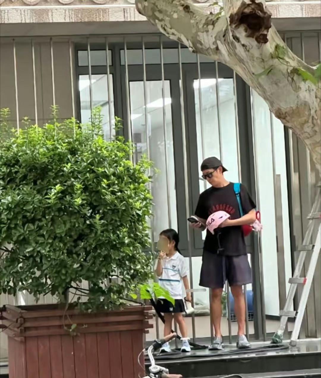 上海街头，王阳，48岁，骑辆自行车，车筐里塞个书包，在幼儿园门口等女儿放学。
