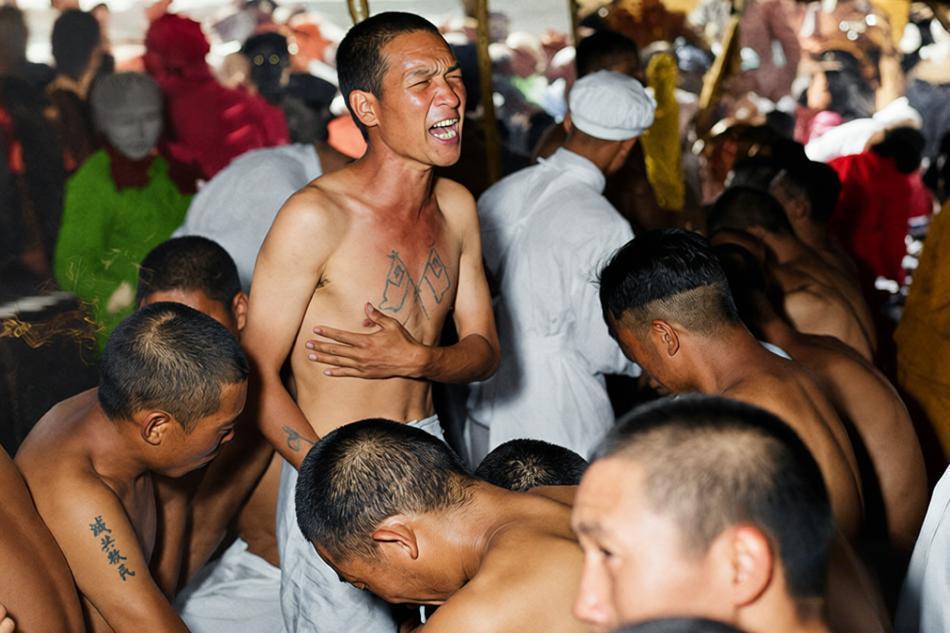 1953年9月，板门店，志愿军战俘赤裸的胸膛上被强行刻下反动标语，他张口嘶吼的神