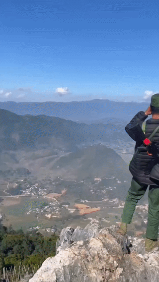 缅甸🇲🇲果敢同盟军的士兵站在中缅边境一座山顶上用望远镜遥望对面的中国县城。