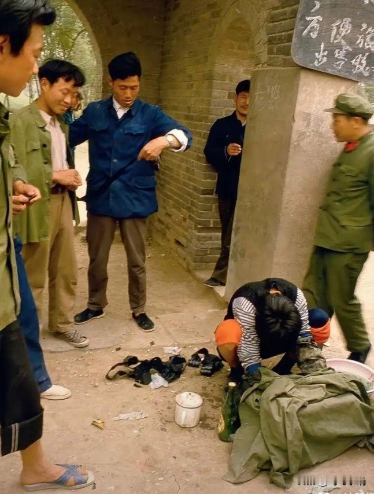 从图片上看，站着的这几个人在看地上坐着的这个人，不知道坐着的这个人在干什么呢？