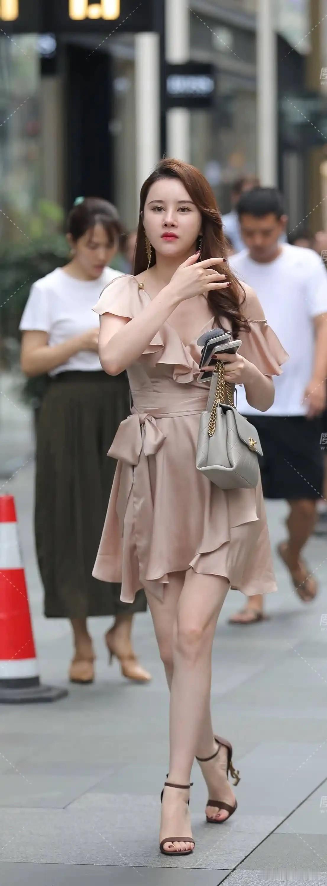 这位女士穿着时尚的连衣裙在街头。
