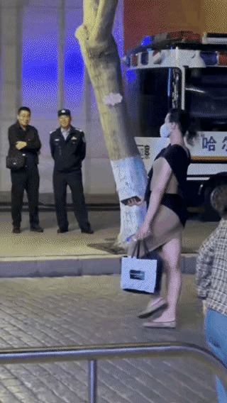 女子昂首挺肚地走在大路上，身体后倾，目视前方，看起来女子很自信，自我感觉良好，走