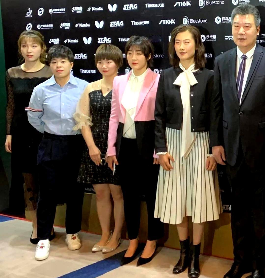 5位国乒女球员与教练盛装同框：李隼西装革履，高大修伟；丁宁秀发垂肩，双腮染赤