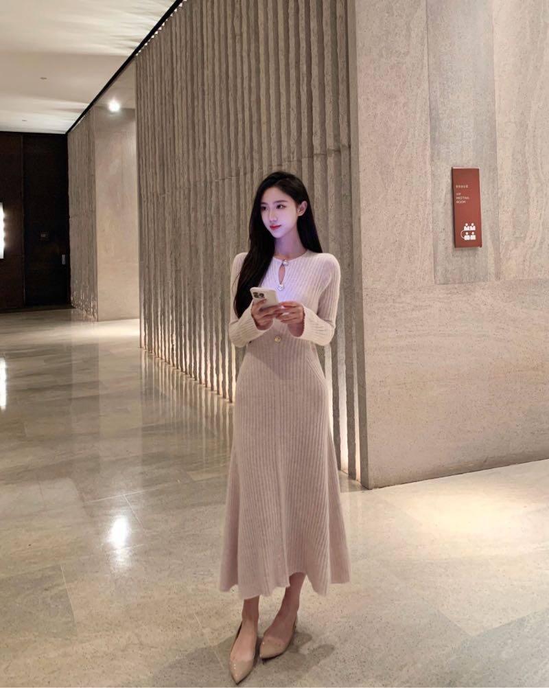 她身着优雅长裙，漫步在时尚都市的街头，指尖轻握手机，目光温柔又从容。城市的霓虹在