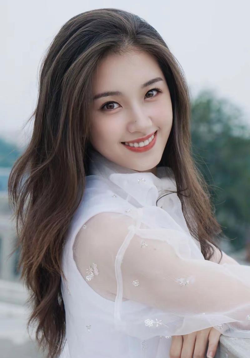 郭宇欣的笑容如春日暖阳般甜润，眼眸弯成月牙时，仿佛藏着星星点点的光。无论是舞台上