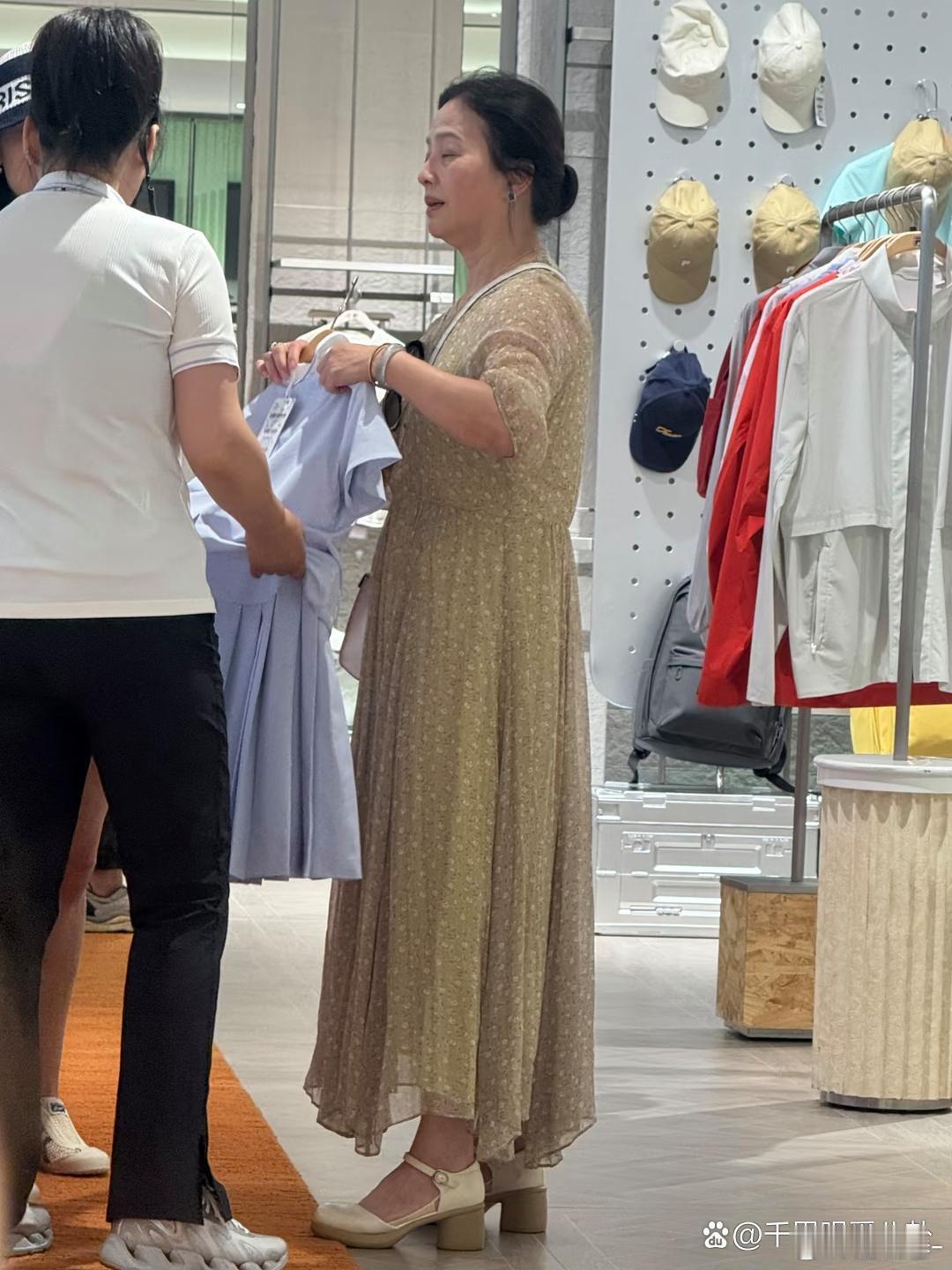 刘亦菲妈妈在北京逛商场被偶遇，她穿着一条黄色碎花裙，挽着发髻，身材微胖，头发乌黑