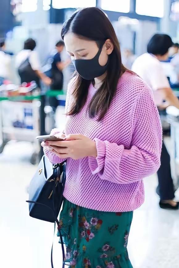陈乔恩的机场穿搭再次成为焦点，一袭紫色毛衣搭配碎花短裙，以巧妙的撞色设计尽显时尚