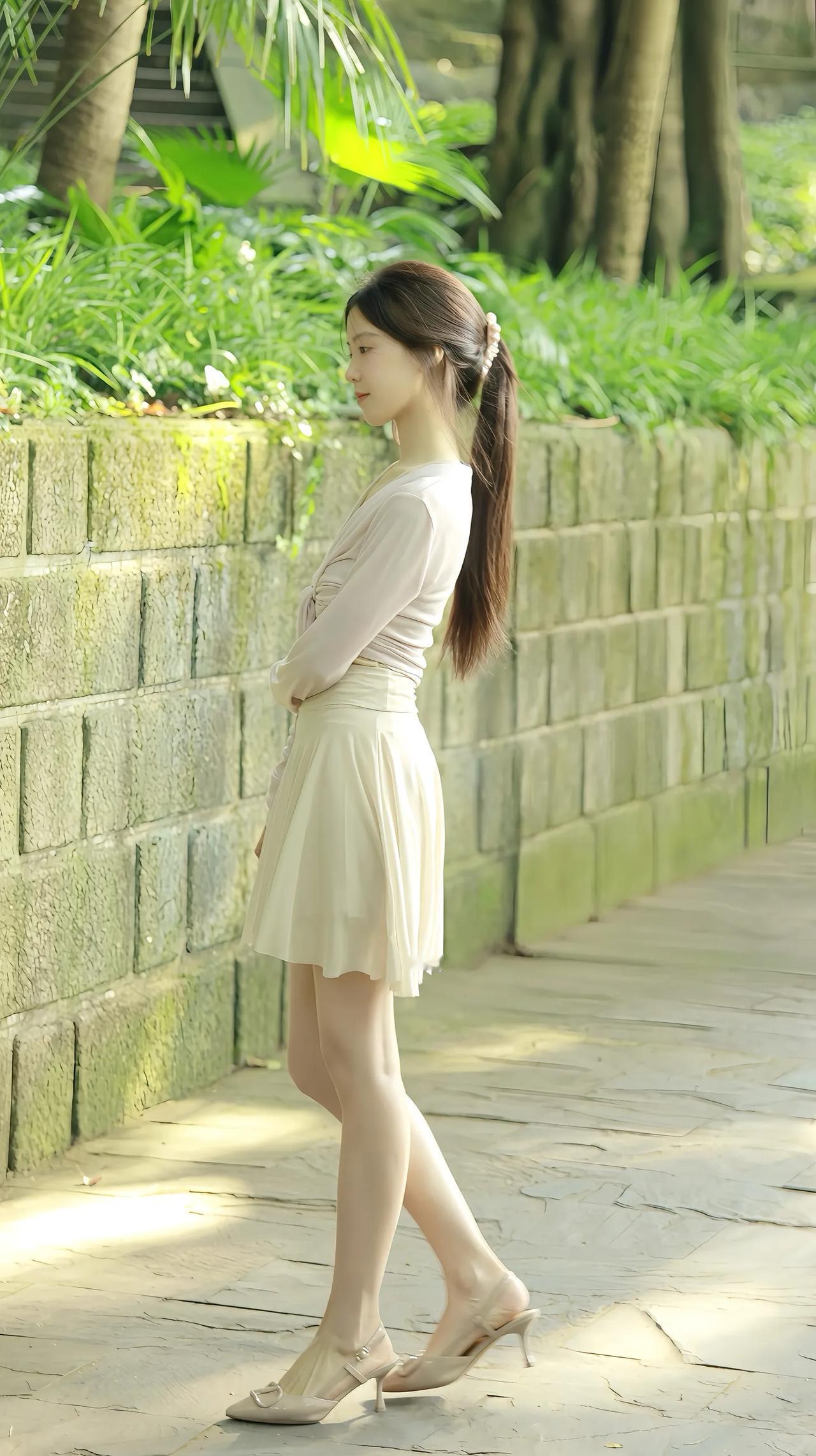 绿树掩映下，少女倚墙思。