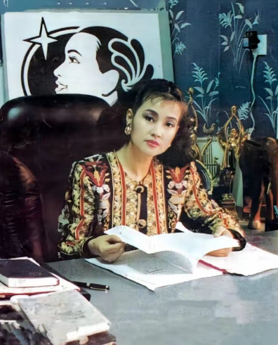 90年代，刘晓庆坐在深圳办公室的一张留影，身后是她的奖杯以及“晓庆牌”的商标，那