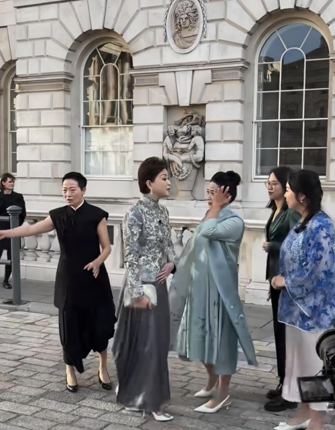 杨澜与前来观展的朋友伦敦萨默塞特宫外合影，身穿银灰色刺绣套装的杨澜高贵，优雅，