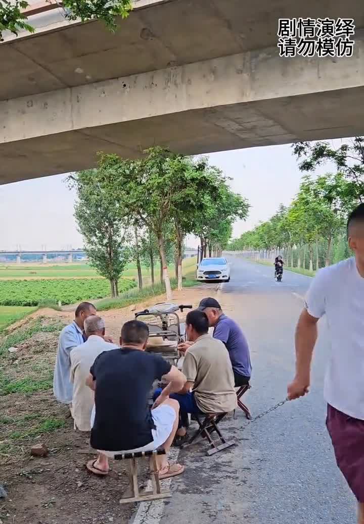 男子牵着小狗看下象棋，这时朋友看到走过来，他偷偷把小狗抱走，然后把铁链拴在旁边椅