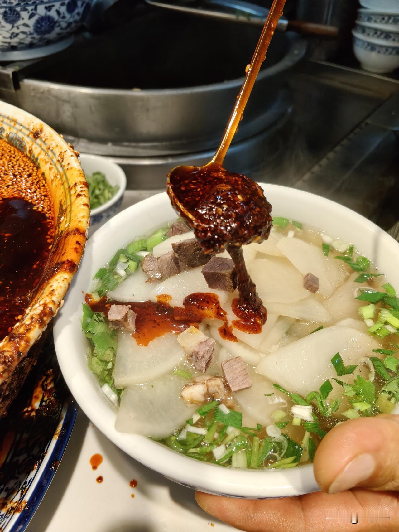 清真慕兰者牛肉面火炬大厦店，就在彭家坪都市休闲公园的东侧。从收银台到拉面小哥的